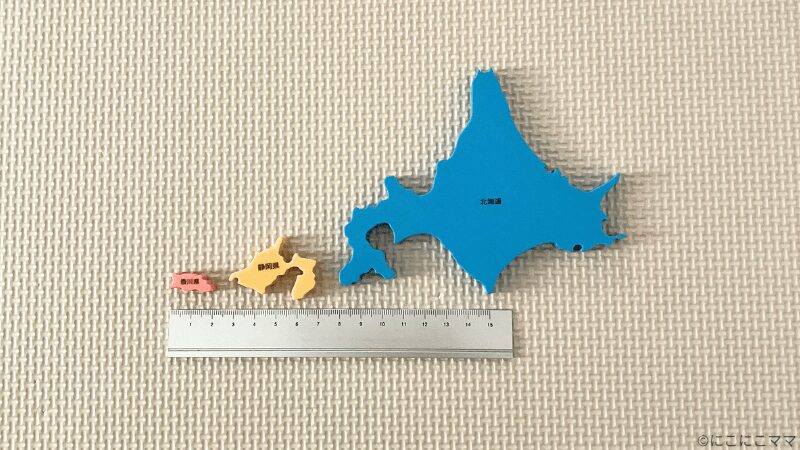 くもんの日本地図パズルのピースのサイズ比較。香川県、静岡県、北海道のピースを定規とともに並べた写真。